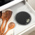 Black digital kitchen scale in drawer next to wooden utensils