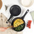 Set of black marble effect non-stick pans and frying pans shown in a kitchen setting