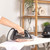 Black and rose gold cordless steam iron in use on ironing board
