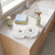 Pair of white mop heads on kitchen counter with cleaning spray and cloths