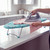 Tabletop ironing board with blue cover and pink top being ironed
