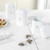 Set of three white kitchen storage tins labelled S, C and T on marble counter