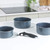 Set of three blue speckled saucepans with removable black handle on kitchen counter