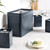 Set of black metal kitchen storage canisters with lids on worktop