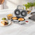 Silver pie maker with two baked pies, beside plate of pie, chips, peas and ketchup.