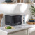 Dark grey microwave with silver handle on kitchen worktop, food and utensils beside