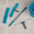 Blue and grey window cleaning set including squeegee, microfibre pads and bucket on tiled floor