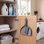 Grey dustpan and brush set hanging inside cupboard door in utility room