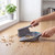 Grey brush and dustpan set sweeping crumbs from a kitchen worktop