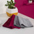 Set of three microfibre cleaning cloths in burgundy, pink, and grey on worktop