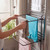 Black folding towel rack attached to radiator, shown holding towels in a bathroom setting