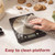 Digital kitchen scale with stainless steel platform being wiped clean, cookies and flour nearby