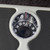 Mechanical bathroom scale with black textured platform, showing close-up of dial.