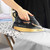 Copper and black Beldray steam iron in use on ironing board