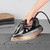 Beldray copper steam iron in use on grey shirt, hand holding handle