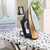 Copper and black steam iron upright on spotted ironing board