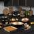 24-piece black and gold cookware and bakeware set displayed in modern kitchen