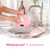 Pink waterproof digital kitchen scale being washed under a tap