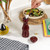 Red glossy wooden pepper mill showing ceramic grinder, angled side view