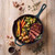 Cast iron pan with roast beef, colourful carrots, potatoes and Brussels sprouts