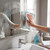 Microfibre cloth cleaning bathroom mirror near sink and spray bottle