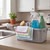 Cleaning kit with spray bottles, scrub brush, and cloths in caddy on kitchen worktop