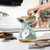 Sage green mechanical kitchen scale with round dial, shown from above.