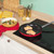 Red non-stick frying pan with stainless steel handle, shown angled on white background