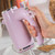 Pink hand mixer in use, shown close-up with speed controls and beaters visible.
