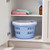 Blue laundry basket with lid in cupboard