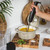 Black and gold handheld stick blender with Salter logo, upright on white background