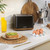 Black two-slice toaster with wood trim on kitchen counter, styled for home use
