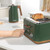 Hand removing crumb tray from green 4-slice toaster on kitchen counter