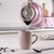 Pink kettle pouring hot water into matching mug on kitchen counter