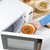 White microwave with door open, hand placing bowl of tomato soup inside