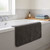 Charcoal grey bath mat displayed on white bath edge in modern bathroom