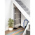 Foldable heated clothes airer stored under stairs, showing slim black and silver design.
