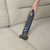 Navy handheld vacuum cleaning crumbs from light grey fabric sofa