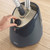 Hand adjusting dial on Beldray garment steamer base, dark grey, shown on wooden surface