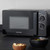 Black Salter microwave oven with manual dials on kitchen worktop