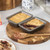 Twin grey non-stick loaf tins filled with berry crumble, one partially served