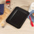 Black non-stick rectangular baking tray shown from side view