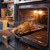 Roast chicken with vegetables in oven tray being placed inside a modern oven