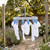 Grey plastic sock airer with blue pegs holding white socks outdoors
