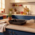 Black roasting tin on a kitchen counter, suitable for oven cooking and baking.