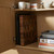 Wooden chopping board and metal baking trays stored in kitchen cupboard, books and mugs on shelf above