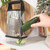 Stainless steel box grater with black handle shown upright