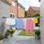 Outdoor washing line with assorted laundry including pink trousers, colourful towels and shorts