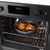 Non-stick blue frying pan with cooked chicken and beans in a built-in oven