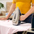 Person ironing pink shirt with Beldray steam iron on ironing board